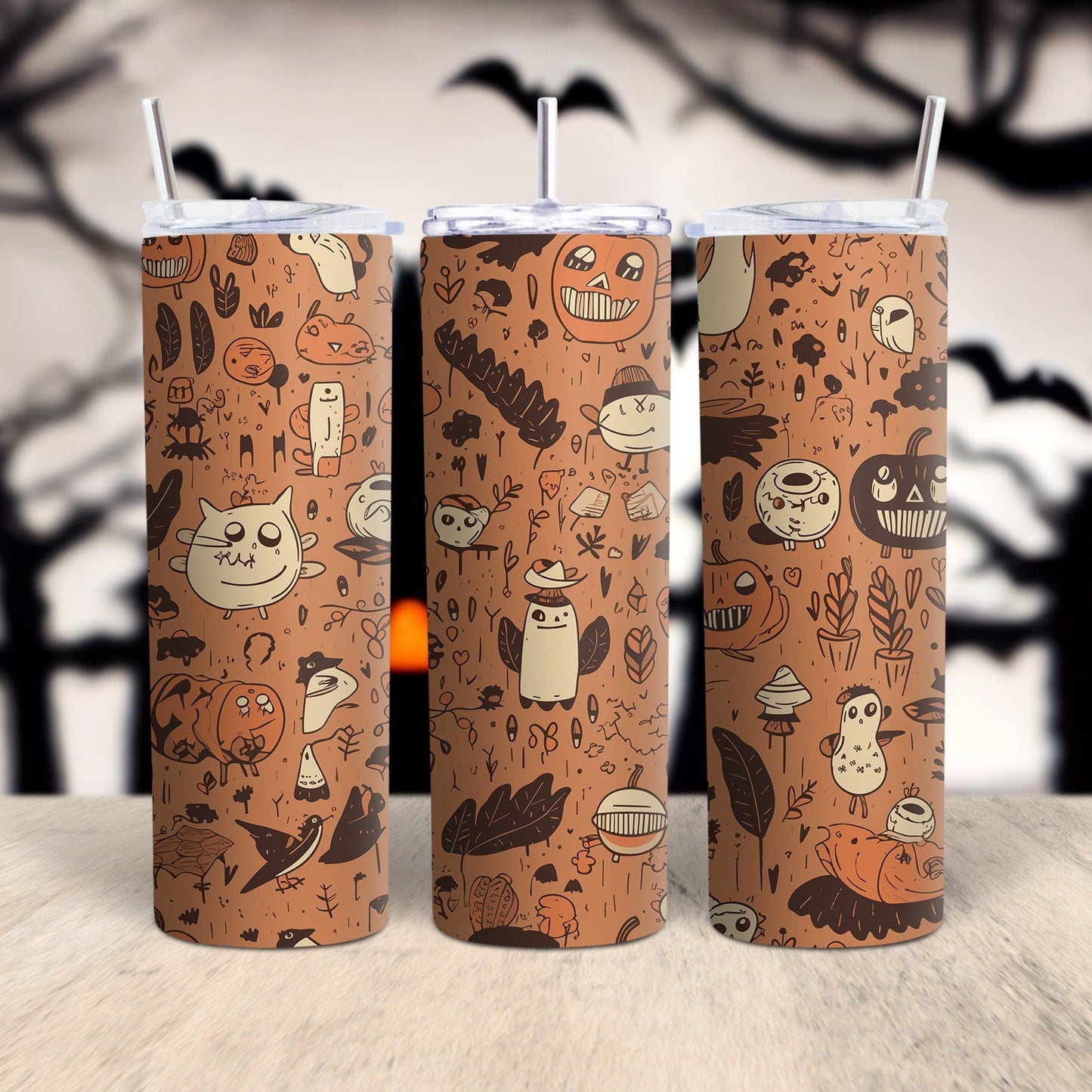 Three Halloween-themed tumblers with a pattern of pumpkins, ghosts, and other spooky elements on a wooden surface with a dark, tree-shadowed background.